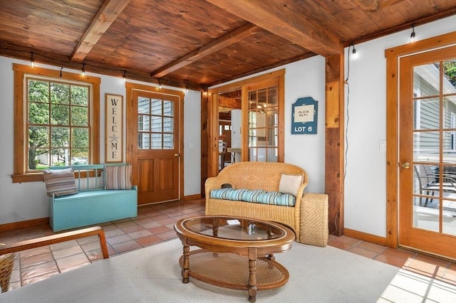 living area with a wealth of natural light, wood ceiling, beamed ceiling, and tile patterned floors