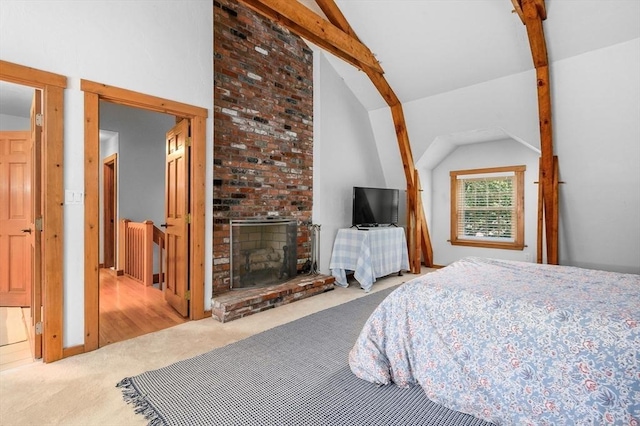 bedroom featuring vaulted ceiling with beams, a fireplace, and carpet flooring