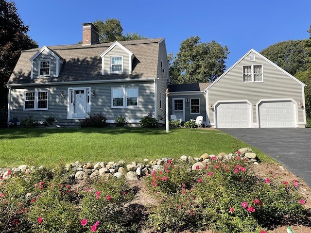 view of front of home with aphalt driveway, an attached garage, a shingled roof, a chimney, and a front yard