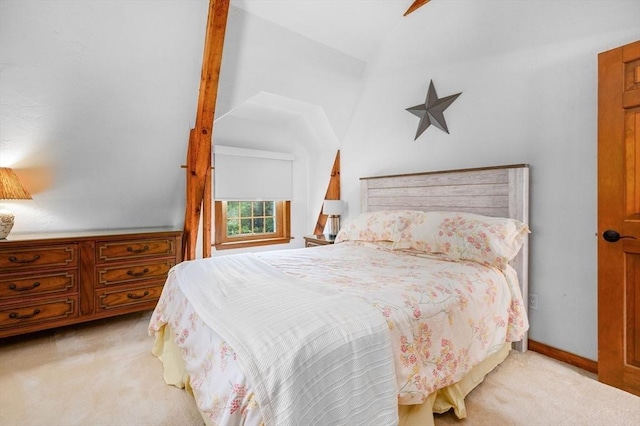 carpeted bedroom featuring baseboards and vaulted ceiling