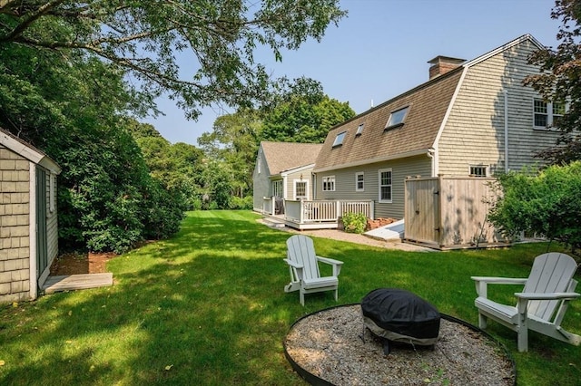 view of yard featuring an outdoor fire pit and a wooden deck