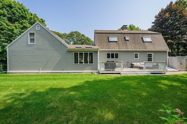 back of house with roof with shingles, an outdoor hangout area, a deck, and a yard