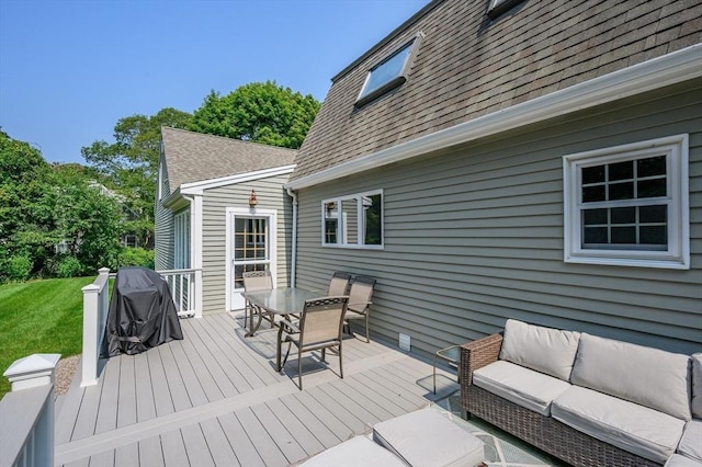 wooden terrace featuring outdoor dining space, a yard, and an outdoor hangout area