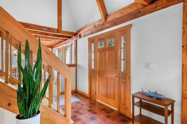 foyer entrance featuring vaulted ceiling with beams and stairway