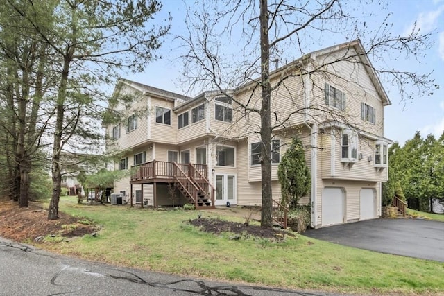 exterior space with a garage, central AC, driveway, and stairway
