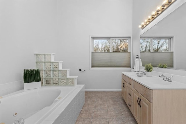 full bathroom featuring vanity, tile patterned flooring, baseboards, and a bath