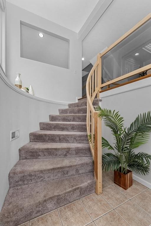 stairs featuring tile patterned floors and recessed lighting