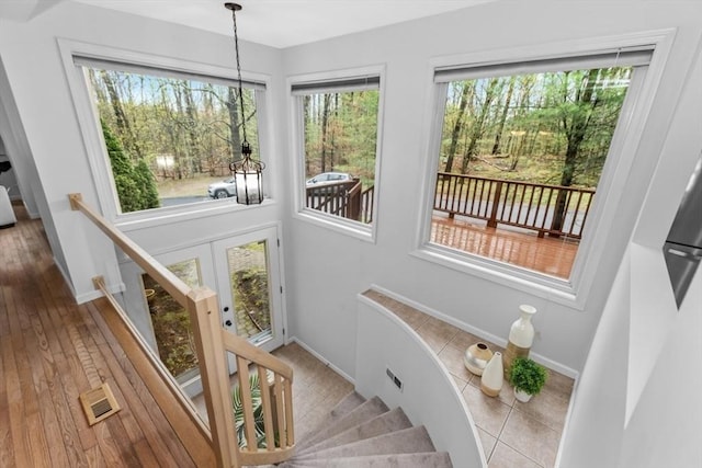 staircase with baseboards, wood finished floors, and visible vents