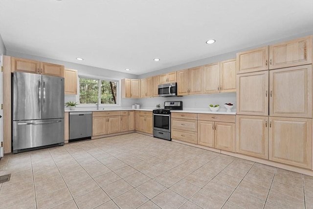 kitchen featuring light countertops, light tile patterned floors, light brown cabinetry, and stainless steel appliances