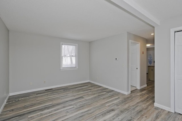 unfurnished room featuring wood finished floors and baseboards