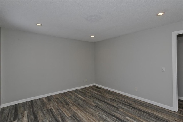 empty room featuring recessed lighting, baseboards, dark wood-type flooring, and a textured ceiling