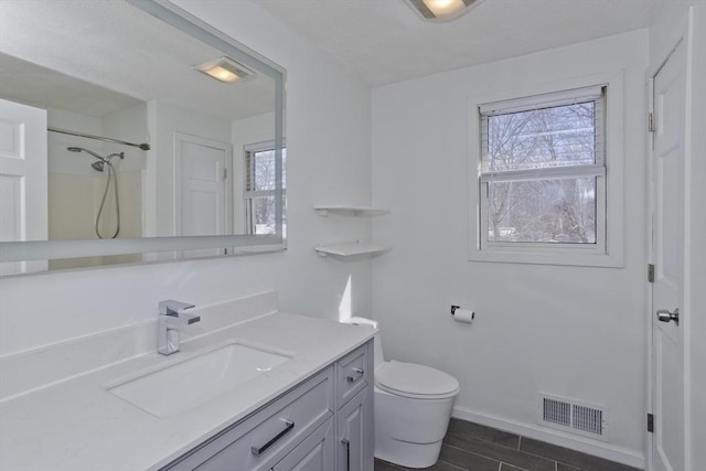 full bathroom with vanity, toilet, visible vents, and a wealth of natural light