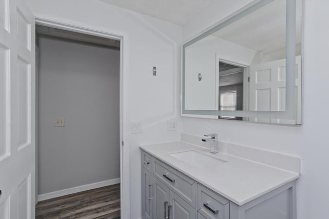 bathroom featuring vanity, baseboards, and wood finished floors