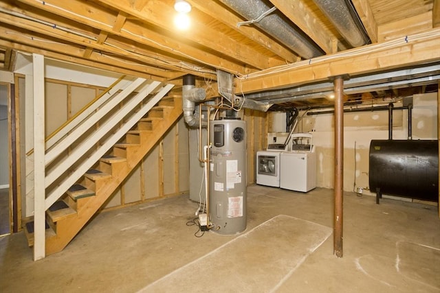 unfinished below grade area featuring stairway, heat pump water heater, heating fuel, and washing machine and clothes dryer