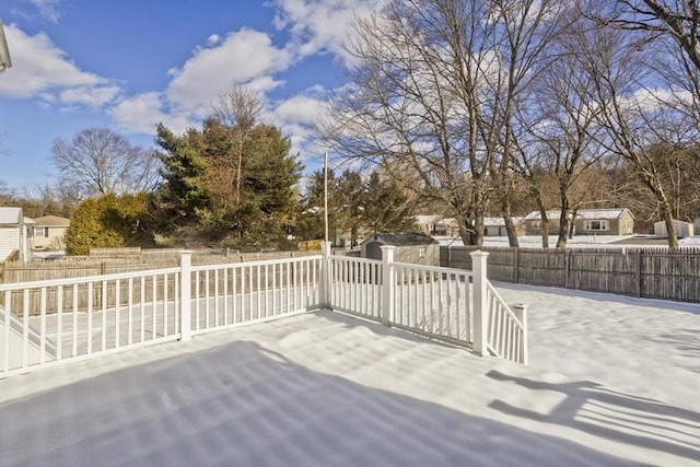 wooden deck featuring a fenced backyard, a shed, a patio, and an outdoor structure