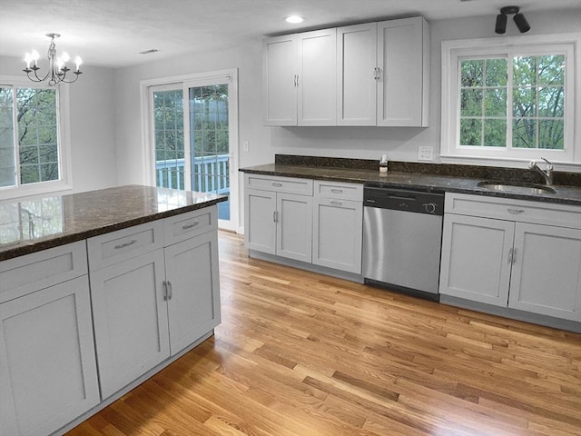 7 Nirvana Dr, Saugus, MA 01906 - kitchen with stainless steel dishwasher, a sink, light wood-style floors, a chandelier, and dark stone counters
