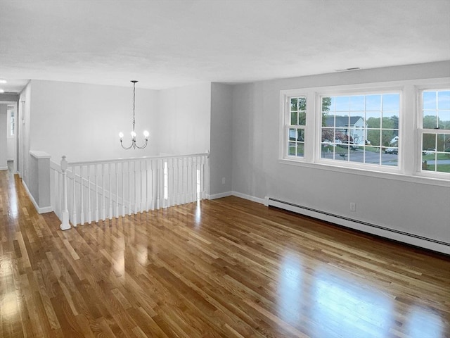 7 Nirvana Dr, Saugus, MA 01906 - spare room with wood finished floors, a chandelier, a baseboard heating unit, and baseboards