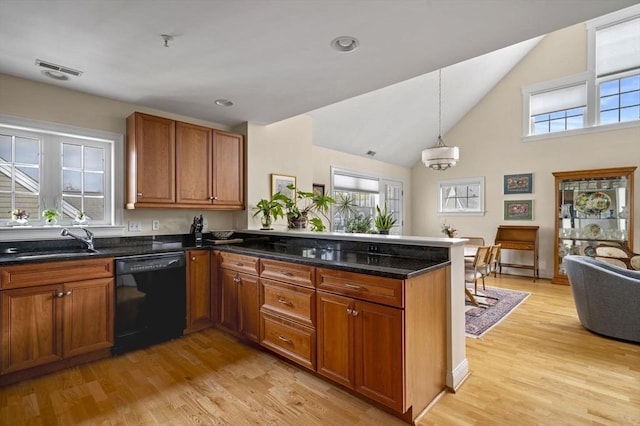 6 Essex Rd Unit 15, Ipswich, MA 01938 - kitchen with brown cabinetry, dishwasher, a sink, a peninsula, and light wood-style floors