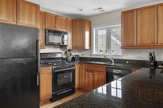 6 Essex Rd Unit 15, Ipswich, MA 01938 - kitchen featuring a sink, light wood finished floors, dark stone countertops, and black appliances