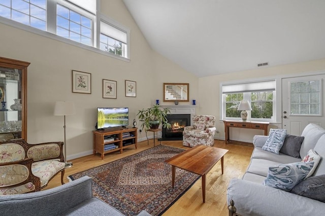 6 Essex Rd Unit 15, Ipswich, MA 01938 - living area with visible vents, a glass covered fireplace, wood finished floors, and high vaulted ceiling