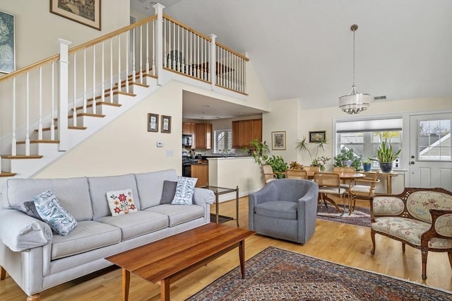 6 Essex Rd Unit 15, Ipswich, MA 01938 - living room featuring high vaulted ceiling, light wood-style flooring, and stairway