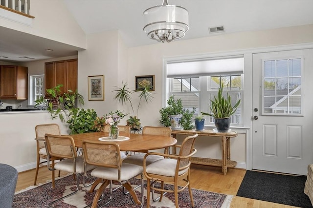 6 Essex Rd Unit 15, Ipswich, MA 01938 - dining area with visible vents, light wood-style flooring, vaulted ceiling, and an inviting chandelier