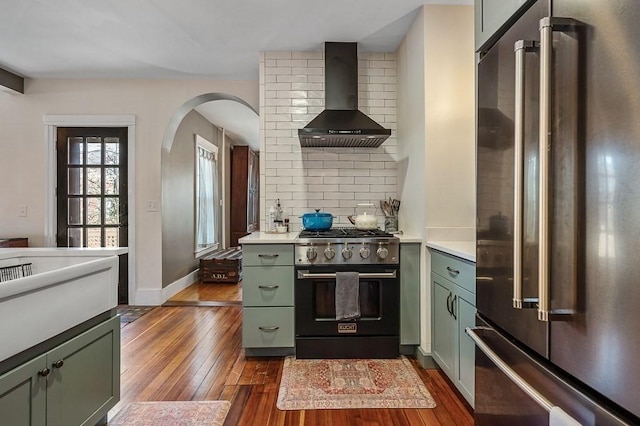 2 Oxford Pl, Worcester, MA 01609 - kitchen with high quality appliances, green cabinets, wall chimney range hood, dark wood-style floors, and backsplash
