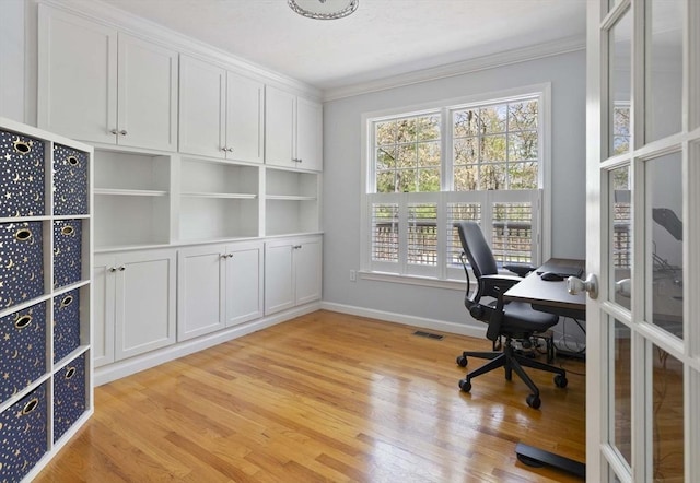 office with light wood-style floors, baseboards, ornamental molding, and visible vents