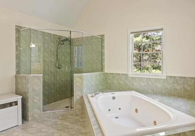full bath with vaulted ceiling, a tub with jets, and a stall shower
