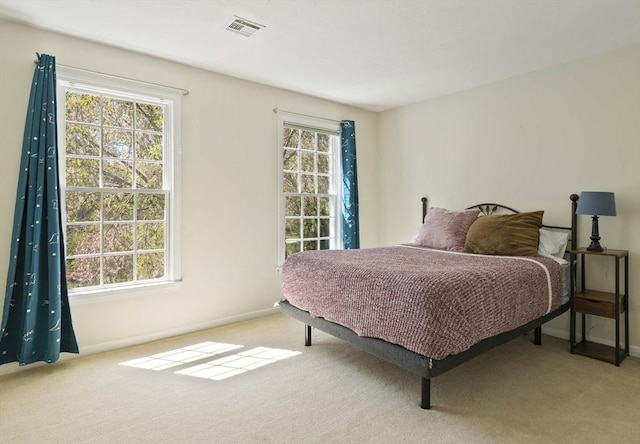 bedroom featuring baseboards, carpet flooring, and visible vents
