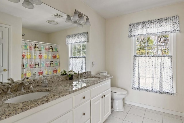 full bath with tile patterned flooring, a sink, double vanity, and toilet