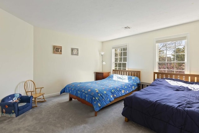bedroom with carpet flooring, baseboards, visible vents, and multiple windows