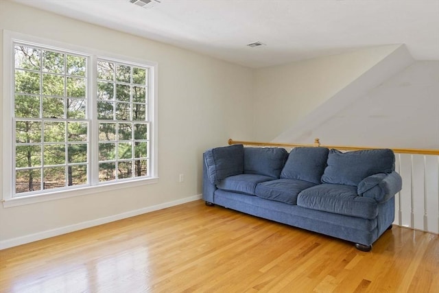 sitting room with baseboards, visible vents, a wealth of natural light, and light wood-type flooring