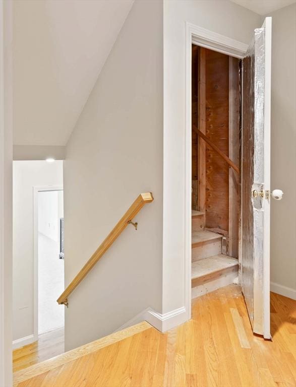 staircase featuring baseboards and wood finished floors