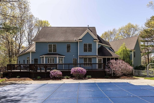 back of property with a fenced in pool, a wooden deck, and fence
