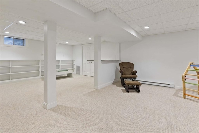 basement featuring carpet flooring, a drop ceiling, and baseboard heating