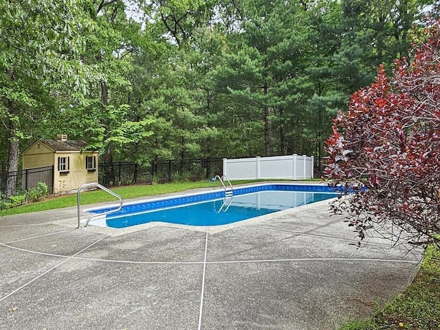 view of pool featuring a fenced backyard, a fenced in pool, an outbuilding, and a patio
