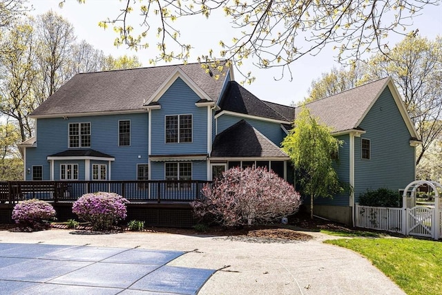back of house featuring a gate, a shingled roof, and a deck