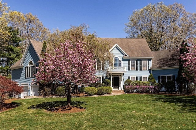 view of front of house with a front lawn and a balcony