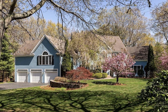 view of front facade with driveway, a front lawn, and a garage