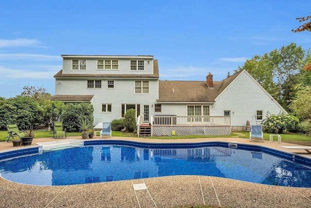 view of swimming pool with a wooden deck and a diving board