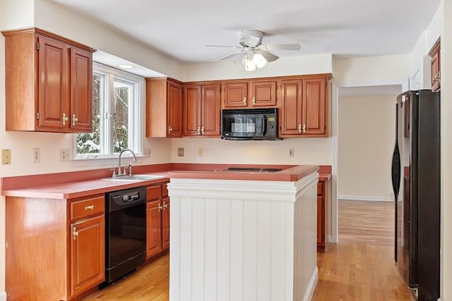 kitchen with sink, black appliances, light hardwood / wood-style floors, and ceiling fan