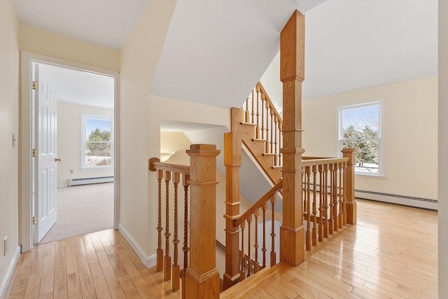 stairway with hardwood / wood-style floors and baseboard heating