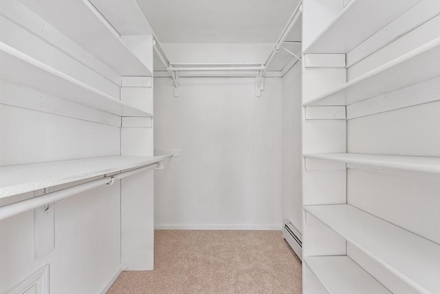 walk in closet featuring light colored carpet and a baseboard heating unit