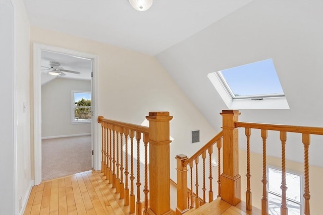 interior space featuring vaulted ceiling with skylight and light wood-type flooring