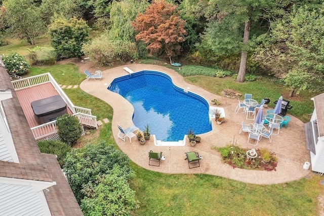 view of pool featuring a wooden deck, a diving board, and a lawn