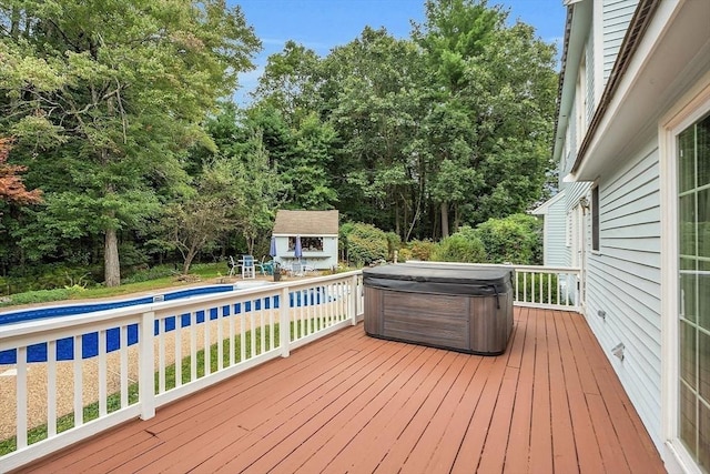 deck with an outdoor structure and a hot tub