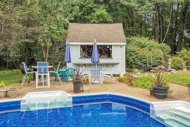 view of pool with an outbuilding