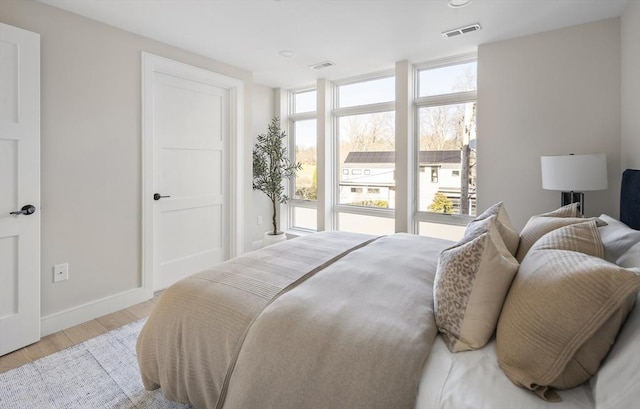 bedroom featuring multiple windows and light wood-type flooring