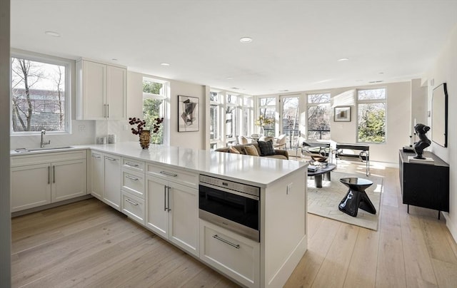 kitchen featuring white cabinetry, light hardwood / wood-style floors, and sink